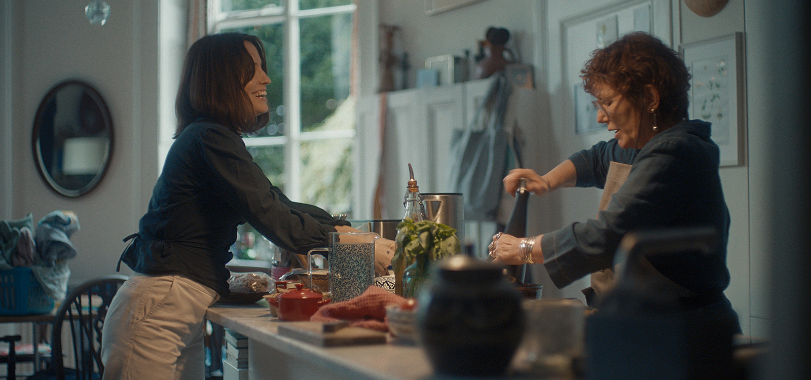 Mujer cuidadora haciendo la comida junto a su madre Mujer cuidadora haciendo la comida junto a su madre